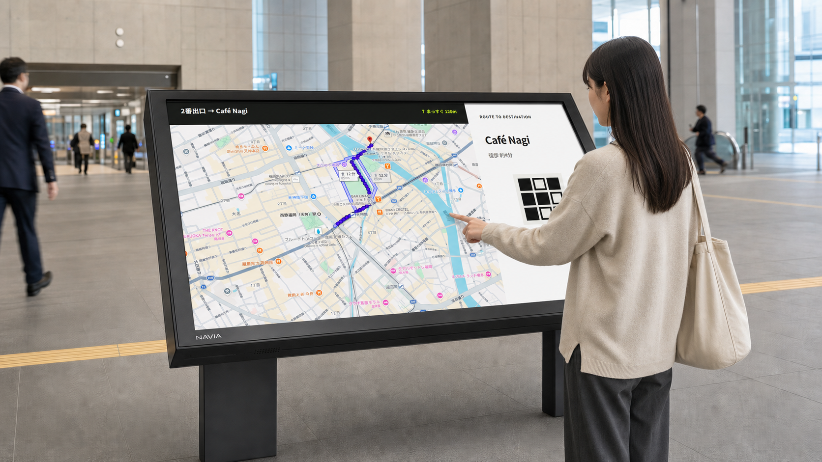 駅構内に設置された横型NAVIAを利用者が操作している様子